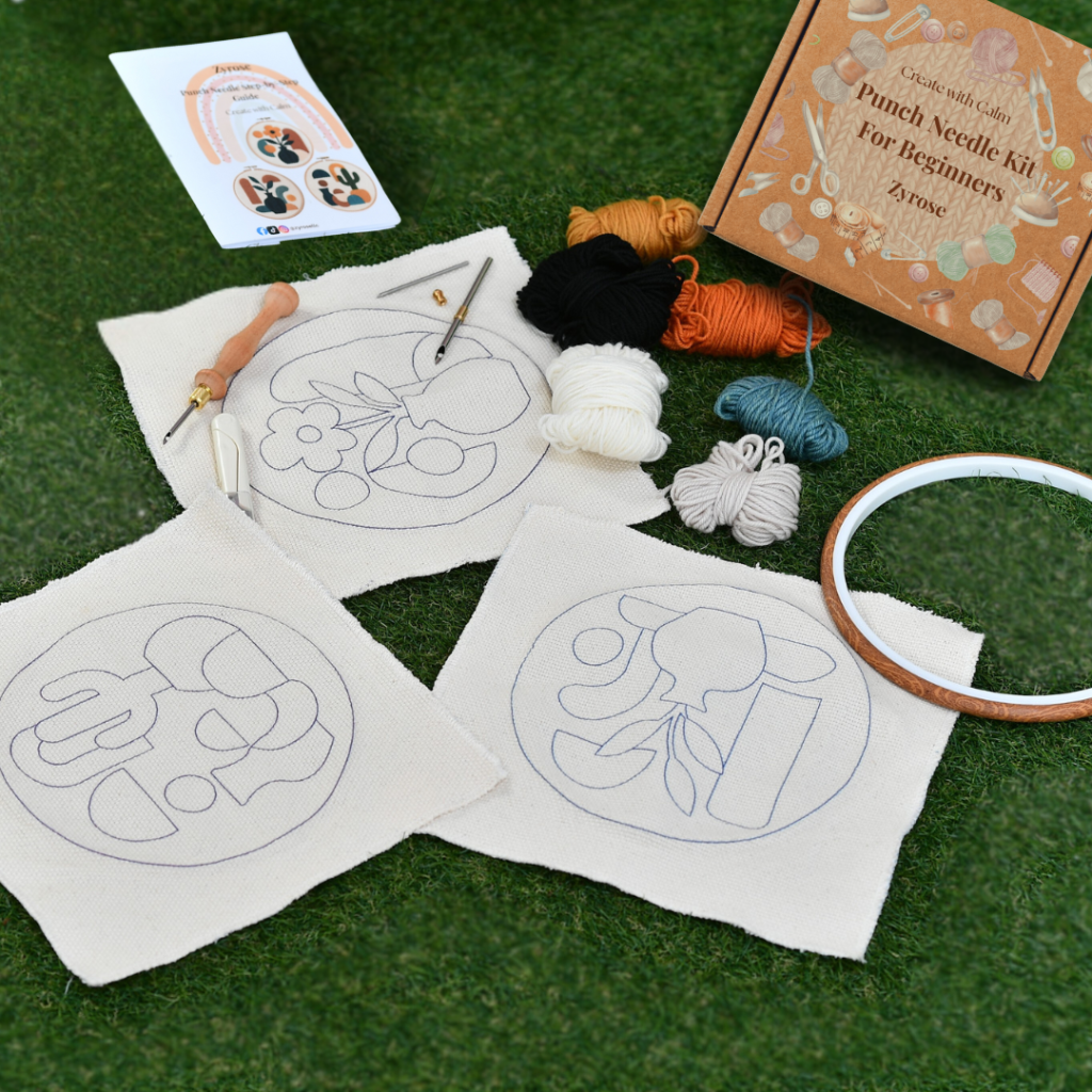 Beginner punch needle kits with patterns, yarn, and tools on table